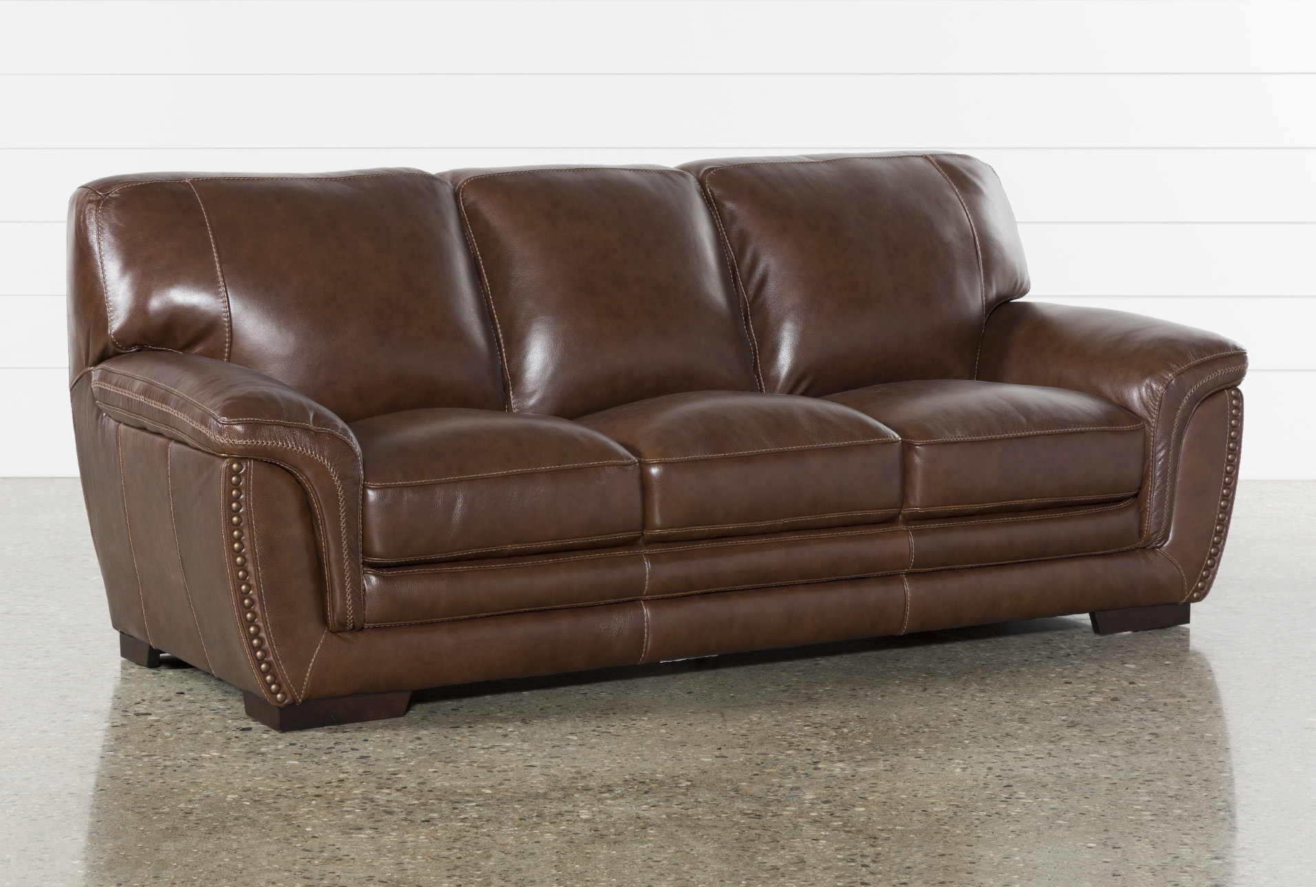 brown leather sofa with red pillows