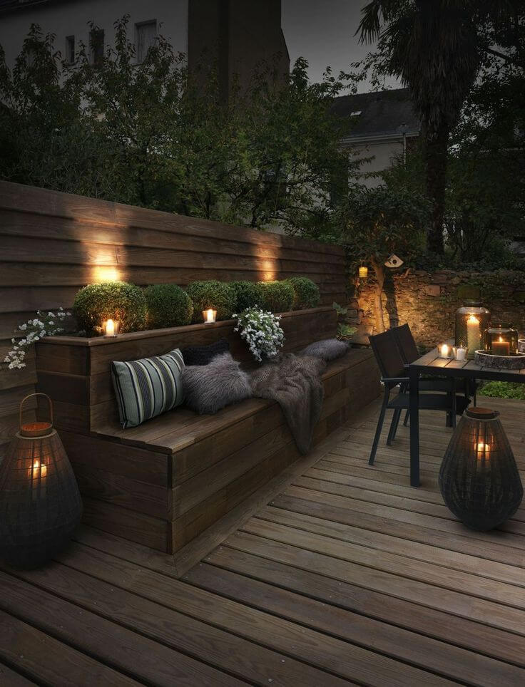 backyard lighting ideas upscale outdoor seating bench lit by candles JXHWUMO