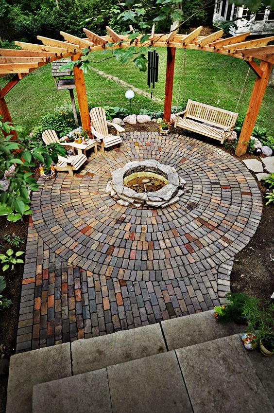 circle-clad brick patio with a fire pit and a swinging day bed XLPMOPP