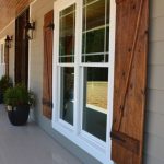 grey exterior with wooden shutters and brick bottom BGSGMRI