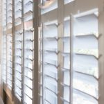 plantation shutters living room with tan walls and white shutters. ZBORRHV