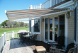 retractable awnings cream and brown striped awning extended over residential deck area JYSHBAR