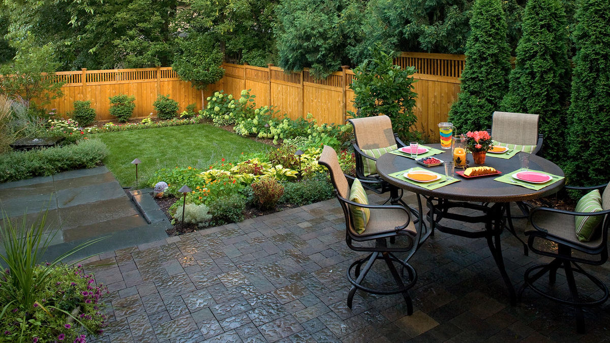 small yard landscaping after: a cedar fence, water feature, dining patio and an edible garden XKSZTOZ