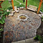 circle-clad brick patio with a fire pit and a swinging day bed XLPMOPP