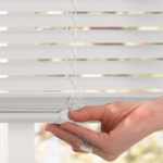 cordless blinds image showing a hand easily lifting/tilting a white cordless vinyl mini SUYMURW