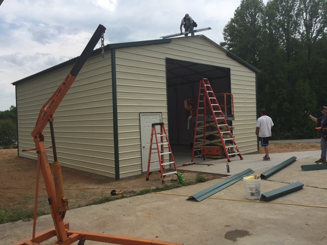 crew building a commercial metal garage, attaching the trim. TAEQWHY