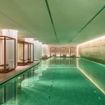 indoor swimming pools indoor pool illuminated water and lounge chairs outside of water MVLUJTI