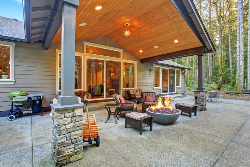 large back yard with grass and covered patio with fire pit XLRHZPZ