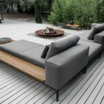 outdoor seating a modern grey upholstered sofa with a wooden shelving for storage PYPIJZB