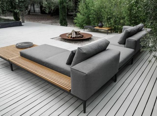 outdoor seating a modern grey upholstered sofa with a wooden shelving for storage PYPIJZB