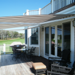 retractable canopy cream and brown striped awning extended over residential deck area IWIGYRV