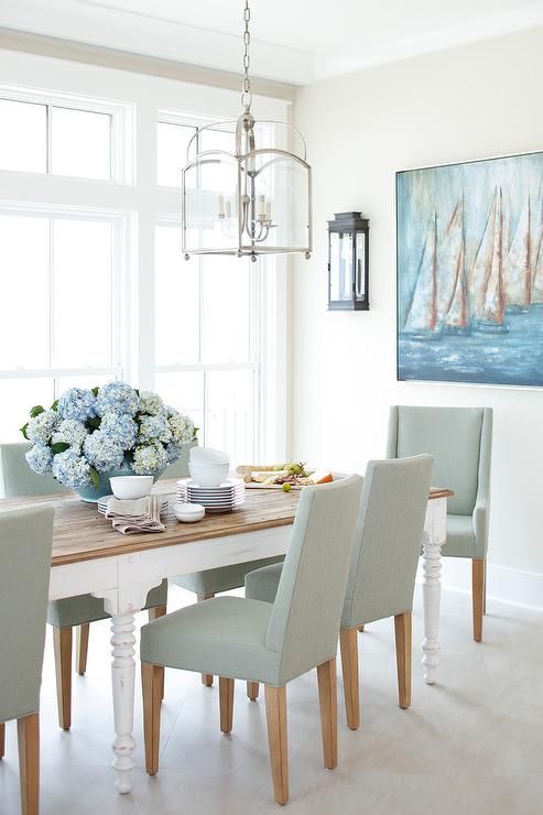 Large dining room windows invite lots of light shining on a white