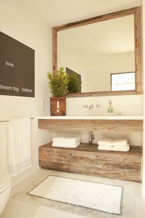 Lovely powder room features reclaimed wood mirror over floating