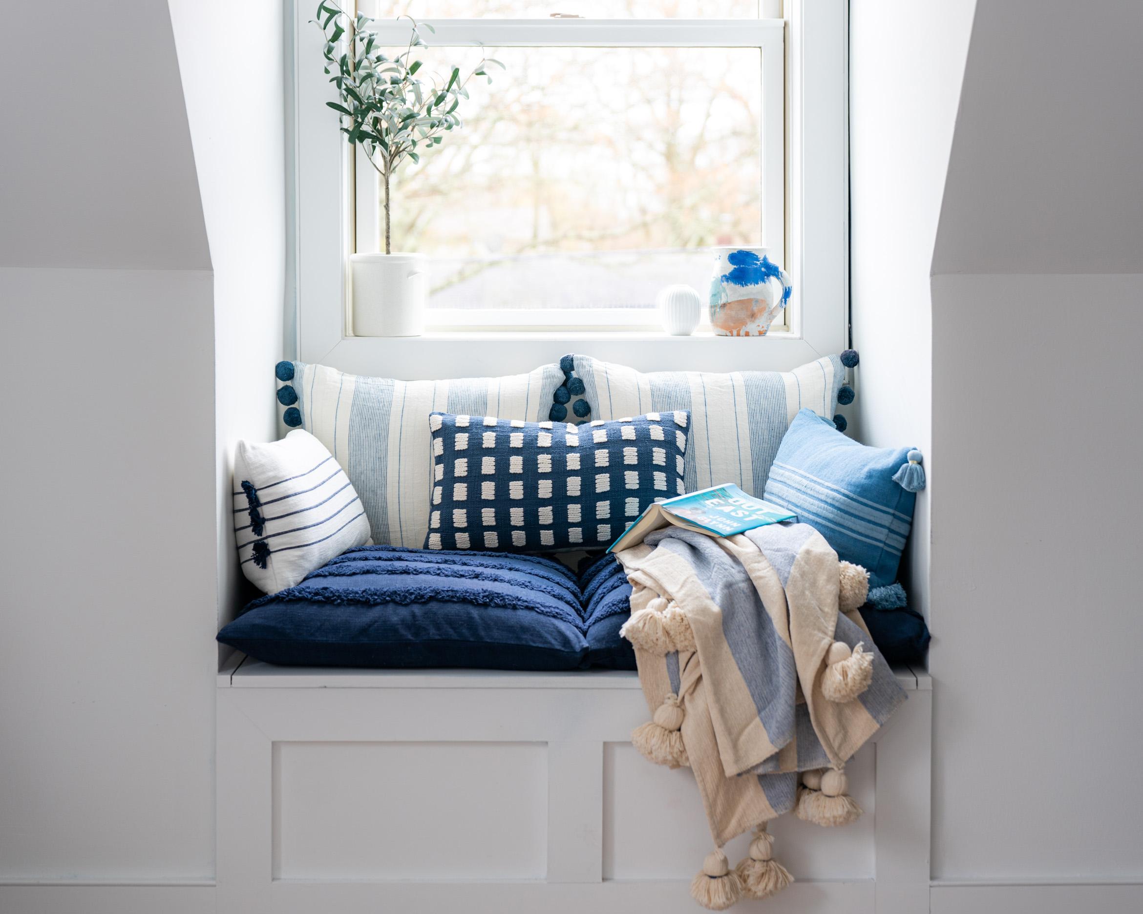 Create a cozy reading nook adorned with ‌blue pillows and throws