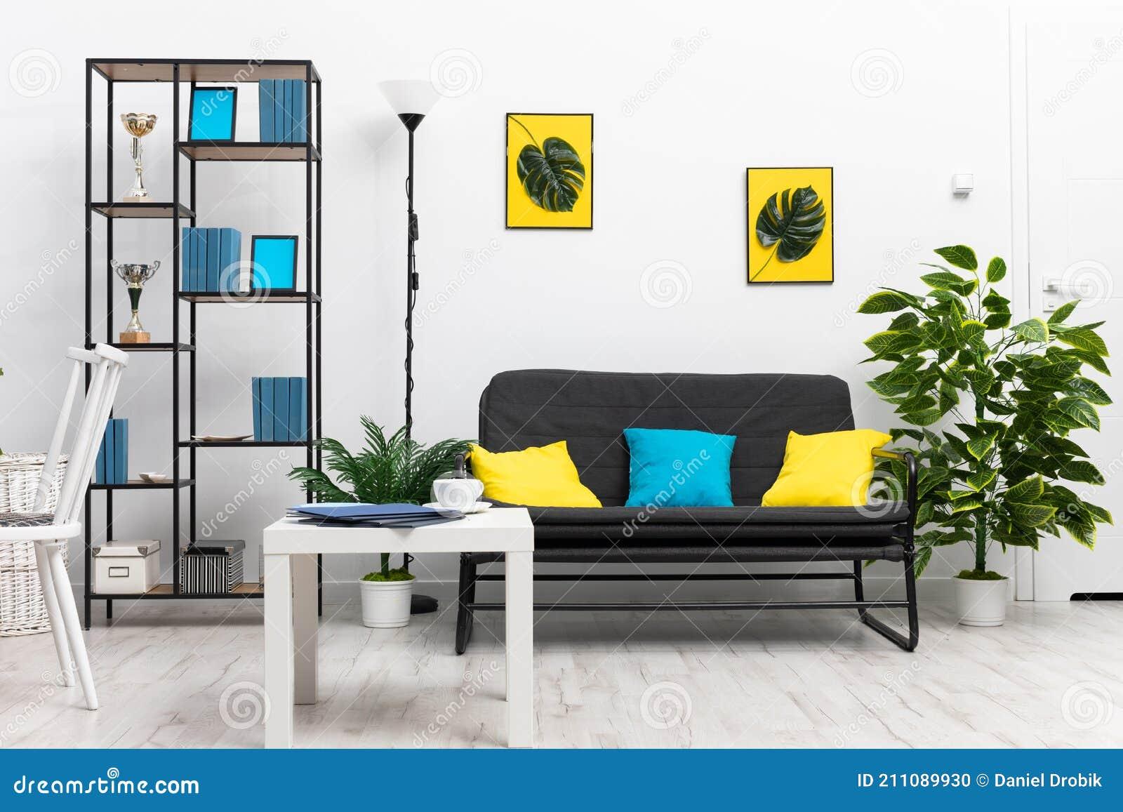 Create contrast with bright yellow accessories‍ in your blue living room