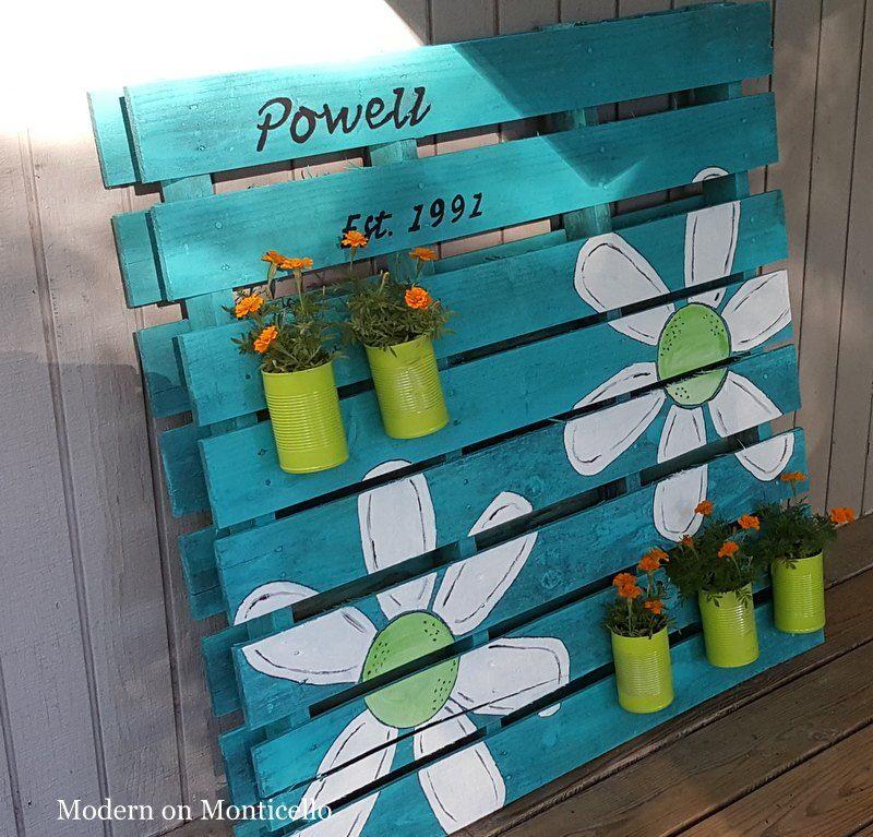 Create a pallet garden mural using vibrant, painted wood