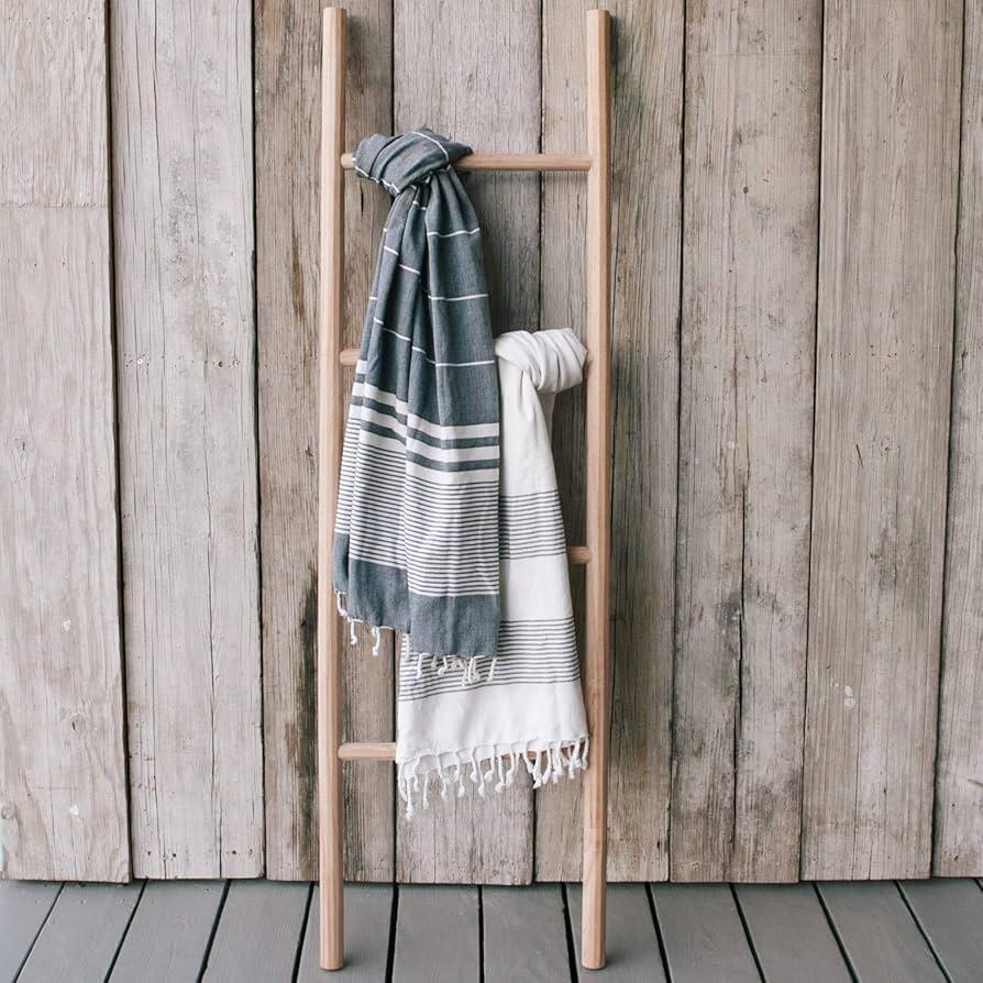 Feature a wooden ladder for towel display​ in your boho bathroom